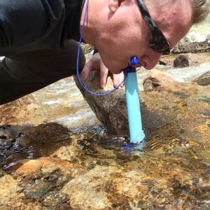 homme buvant eau de la riviere avec lifestraw