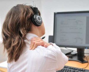 femme avec des douleurs au cou et aux épaules au travail