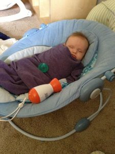 bébé dormant dans un landau à coté du baby shusher